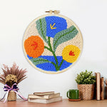 Finished orange, blue and yellow blooms artwork displayed on a wall
