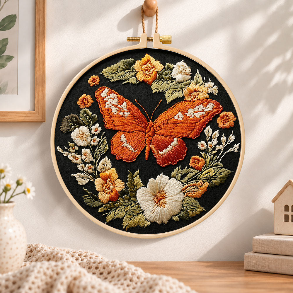Orange butterfly amid blooms embroidery hoop wall art displayed as warm and cozy handmade home decor
