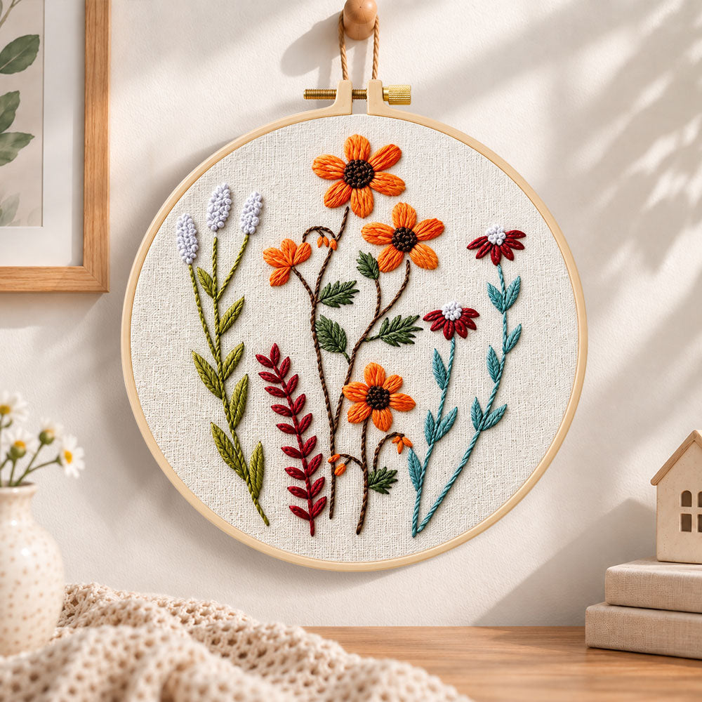 Orange daisy wildflower embroidery hoop wall art displayed as warm and cozy handmade home decor