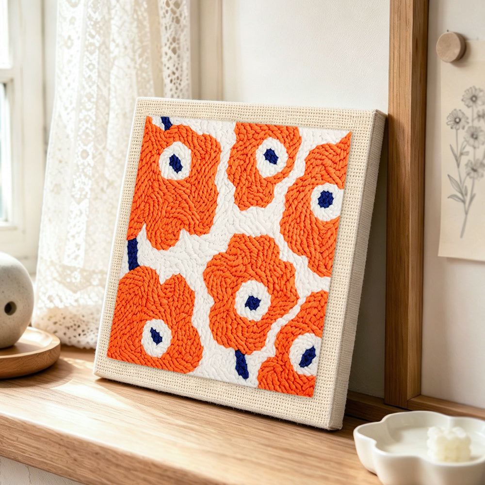 Orange flowers punch needle artwork displayed on a table