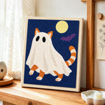 Orange ghost cat under full moon punch needle artwork displayed on a table