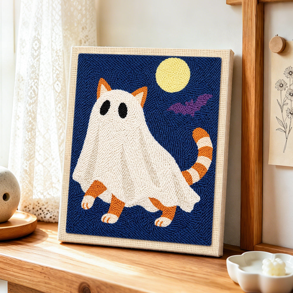 Orange ghost cat under full moon punch needle artwork displayed on a table