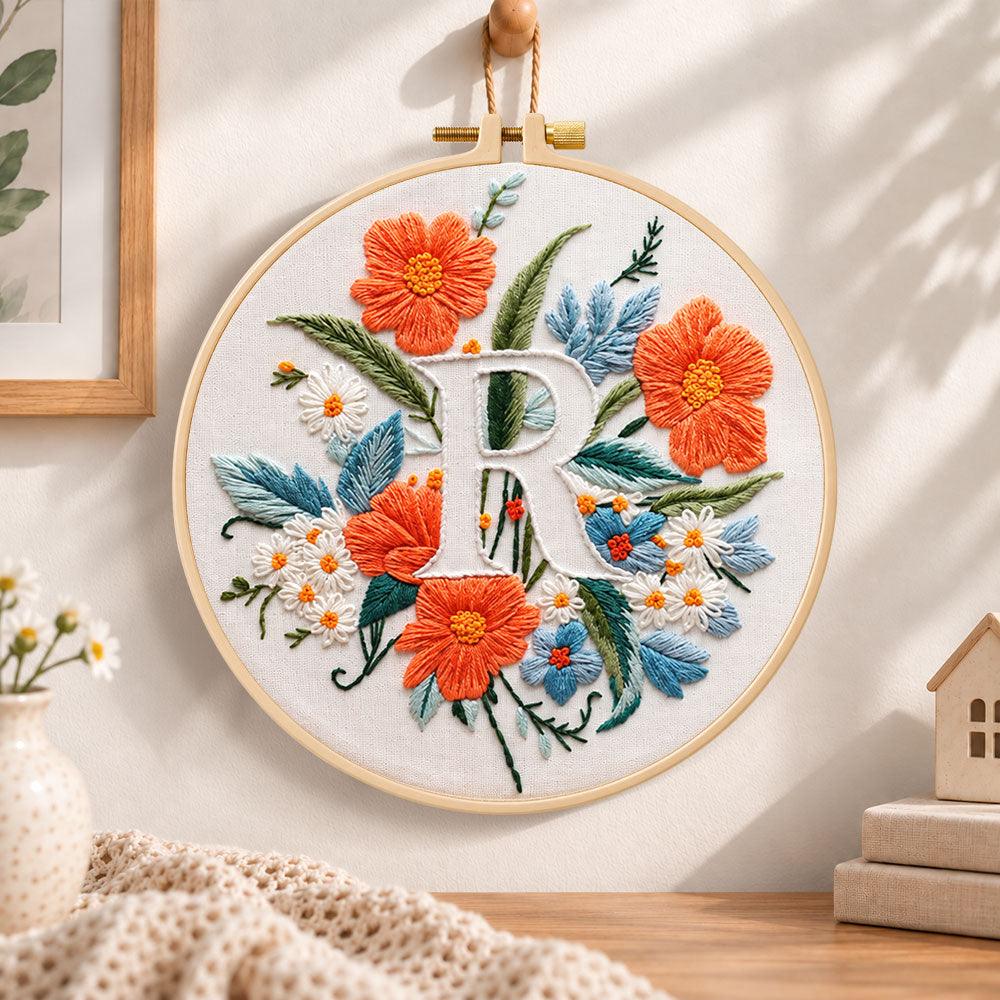 Orange poppies and letter r embroidery hoop wall art displayed as warm and cozy handmade home decor