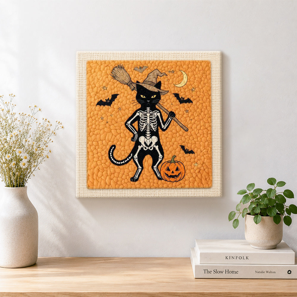 Finished orange skeleton witch cat artwork displayed on a wall
