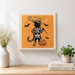 Finished orange skeleton witch cat artwork displayed on a wall