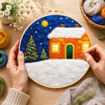 Creating the orange snowy house and christmas trees wool painting by hand with a felting needle