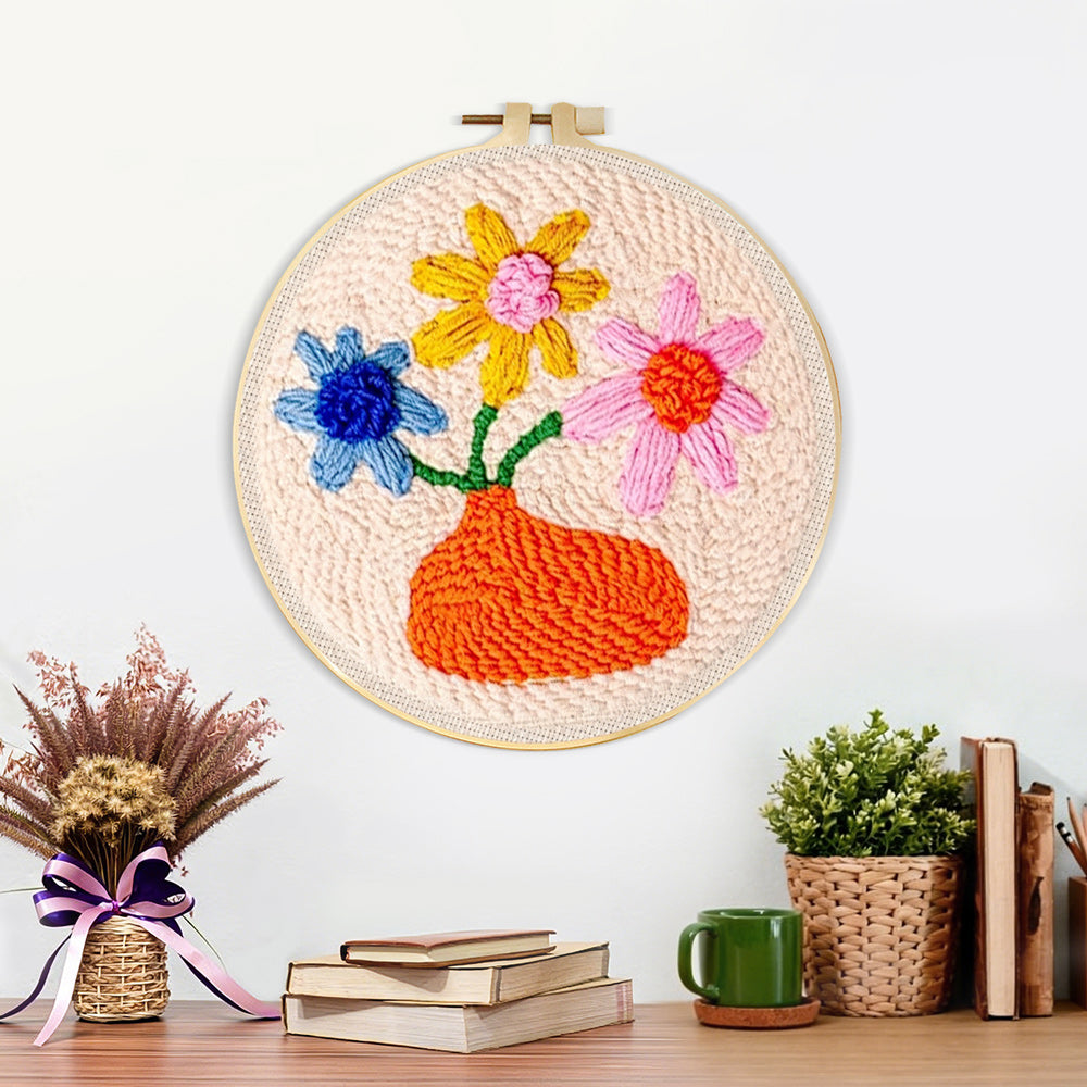 Finished orange vase with colorful flowers artwork displayed on a wall
