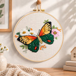 Orange‑winged butterfly embroidery hoop wall art displayed as warm and cozy handmade home decor