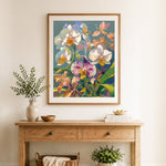 Finished orchid blooms and leaves cross stitch artwork displayed as home decor