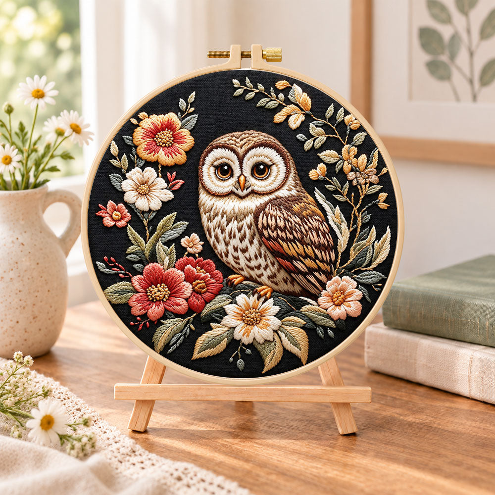 Owl on dark floral embroidery kit finished hoop displayed on a wooden stand as cozy tabletop decor