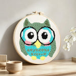 Owl with glasses punch needle artwork displayed on a table