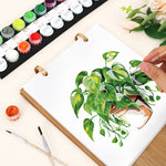 Close-up of painting a leafy potted houseplant on the Botanical Greens calendar with numbered paints and brushes