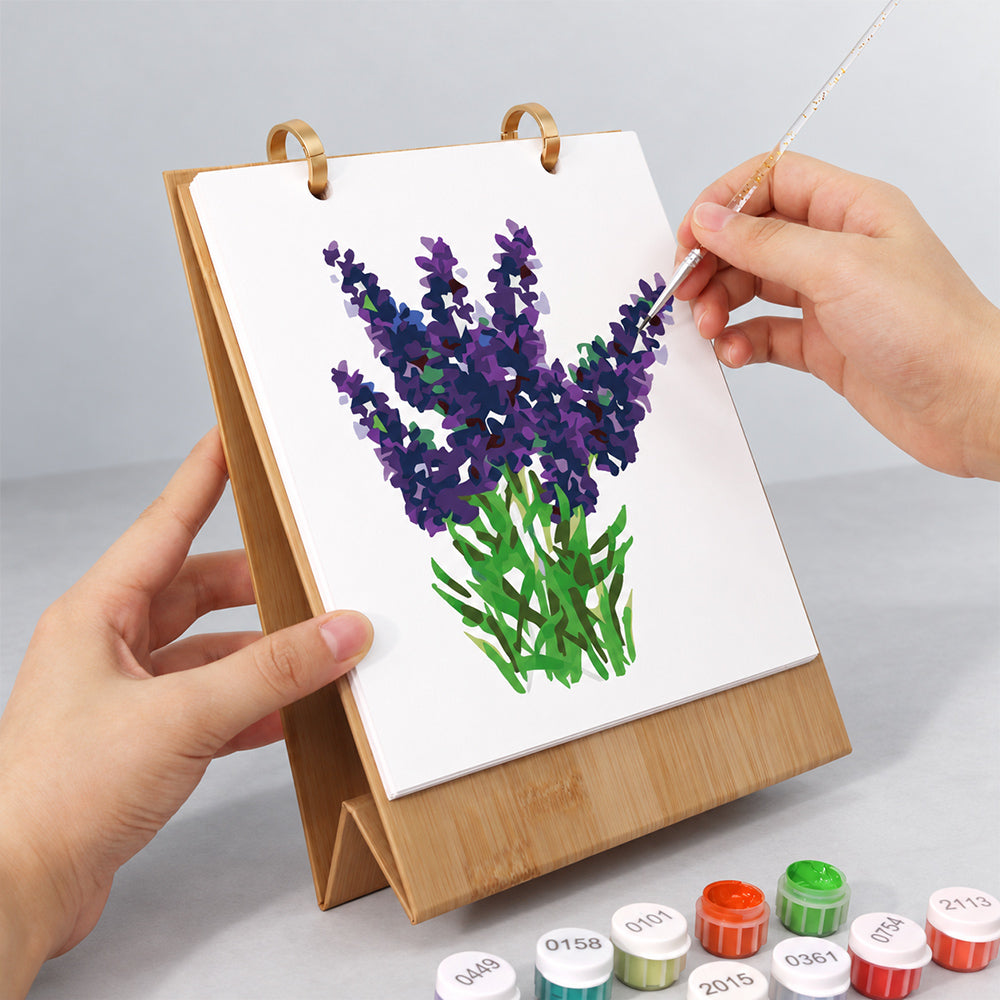 Hands painting a purple lavender design on the floral paint by numbers desk calendar