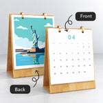 Front and back view of the Iconic Landmarks desk calendar showing monthly dates and a finished Statue of Liberty painting