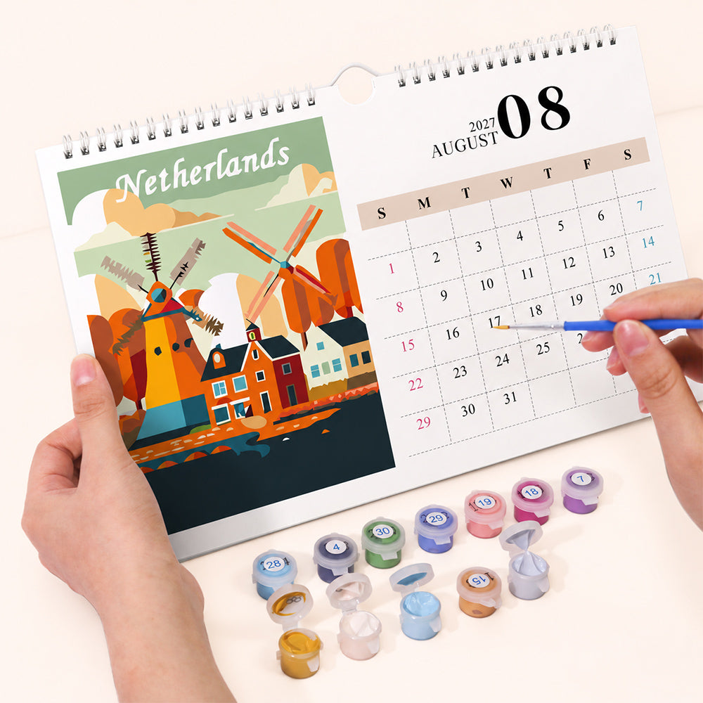 Hands holding and painting the Netherlands windmill design on the August calendar