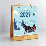 On the Move Paint by Numbers Calendar displayed upright on a wooden stand with a winter horse-drawn sleigh illustration