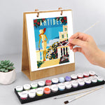 Hand painting a colorful Antibes seaside illustration on the Scenic Getaways Paint by Numbers Desk Calendar