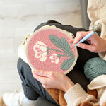 Creating handmade pale pink background with white flowers punch needle artwork