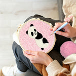 Creating handmade panda on pink background punch needle artwork