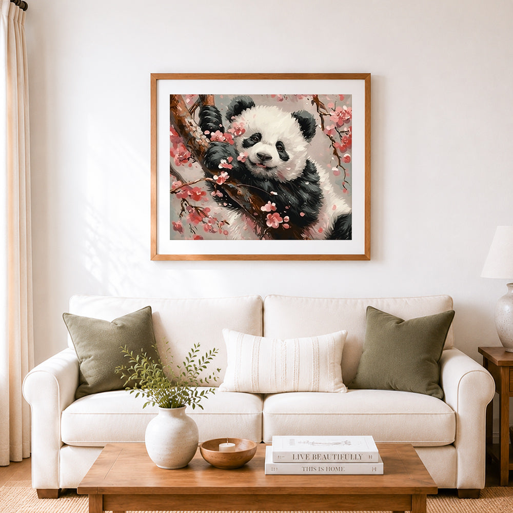Finished panda resting on cherry branches cross stitch artwork displayed as home decor