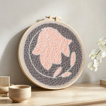 Pastel pink flower punch needle artwork displayed on a table