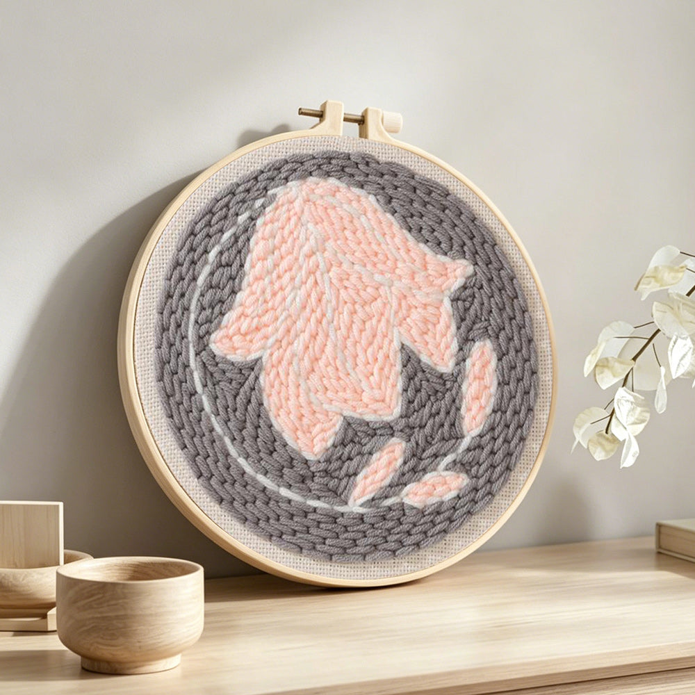 Pastel pink flower punch needle artwork displayed on a table