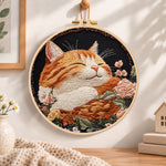 Peaceful sleeping tabby cat embroidery hoop wall art displayed as warm and cozy handmade home decor