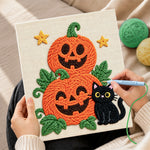 Creating handmade pile of pumpkins with black cat punch needle artwork