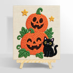 Pile of pumpkins with black cat punch needle kit for beginners