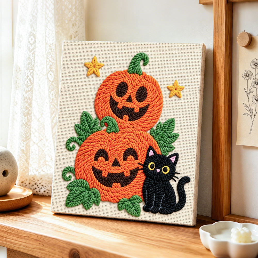 Pile of pumpkins with black cat punch needle artwork displayed on a table