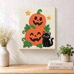 Finished pile of pumpkins with black cat artwork displayed on a wall