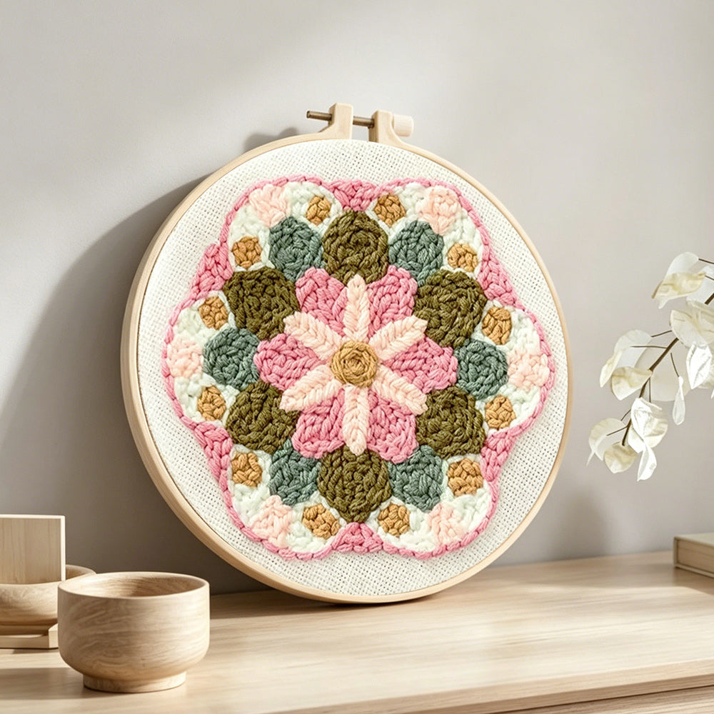 Pink and green flower mandala punch needle artwork displayed on a table