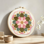 Pink and green flower mandala punch needle artwork displayed on a table