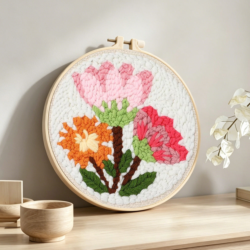 Pink and orange blooms bouquet punch needle artwork displayed on a table