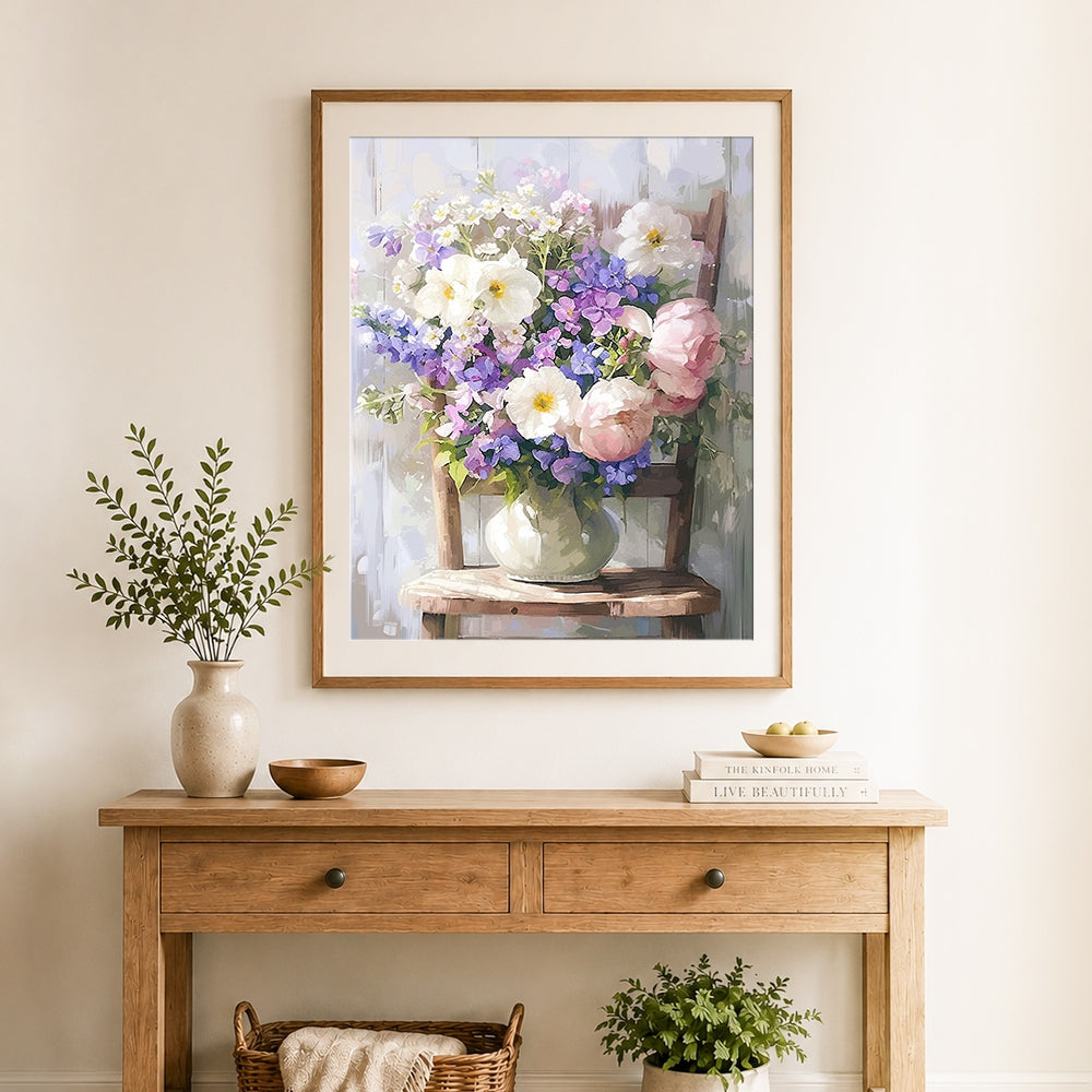Finished pink and purple floral arrangement on wooden chair cross stitch artwork displayed as home decor