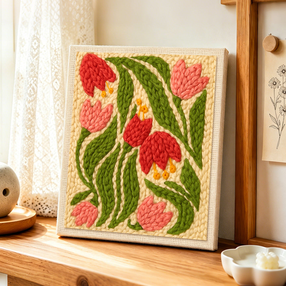 Pink and red bell flowers punch needle artwork displayed on a table