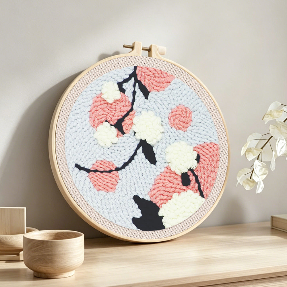 Pink and white blossoms punch needle artwork displayed on a table