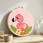 Pink baby flamingo punch needle artwork displayed on a table