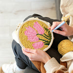 Creating handmade pink blooms on mustard yellow background punch needle artwork