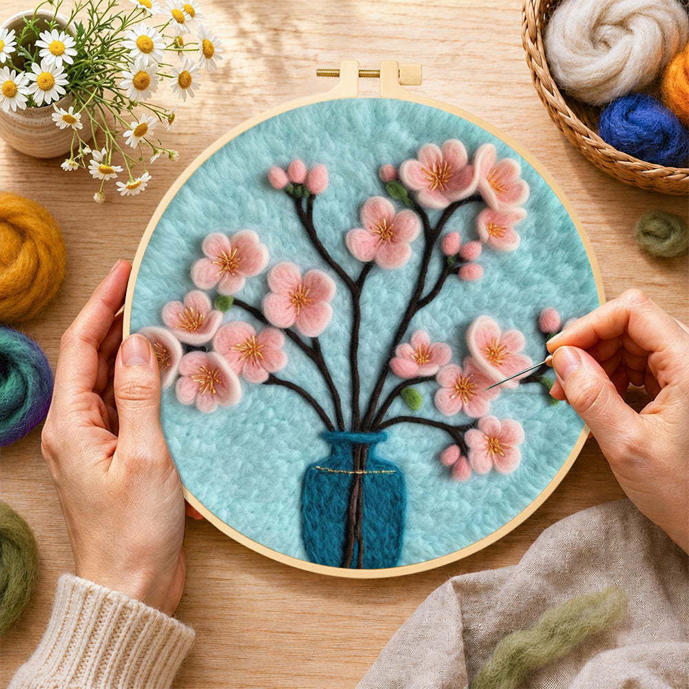 Creating the pink blossom in blue vase wool painting by hand with a felting needle