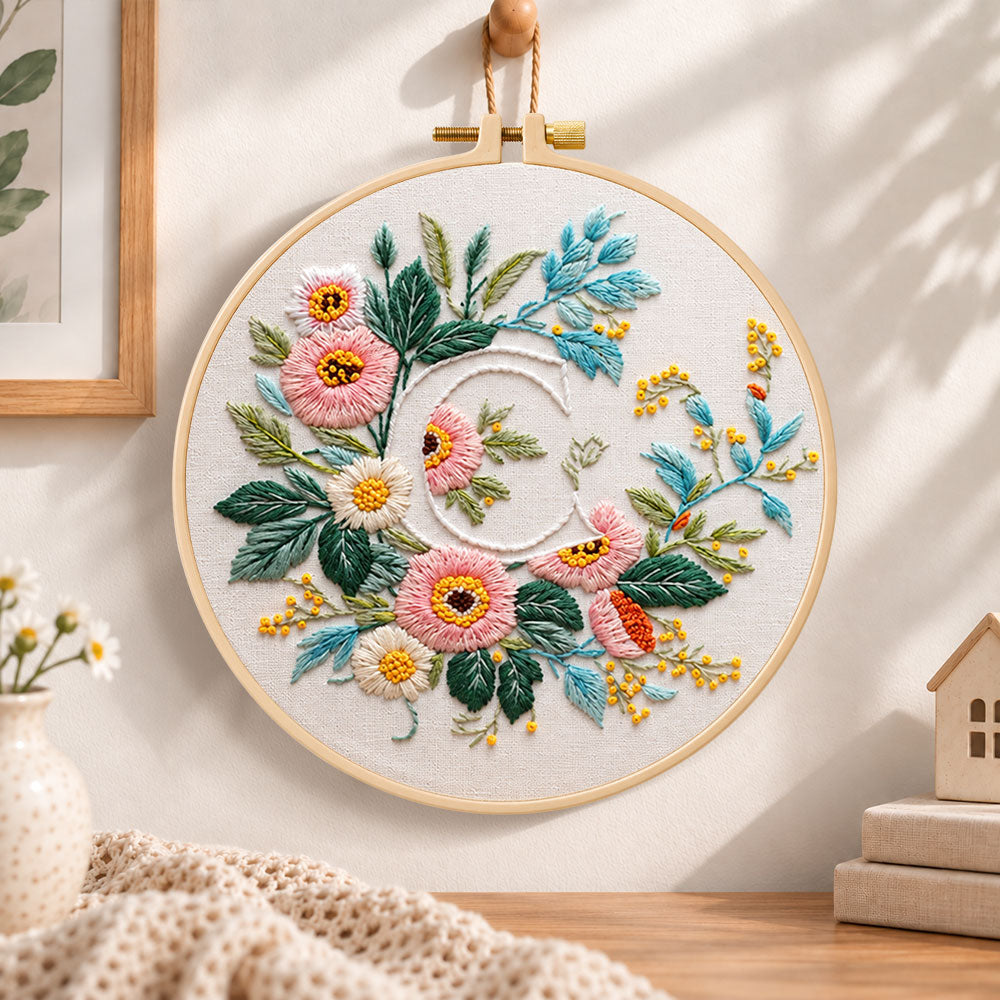 Pink botanical blooms and letter c embroidery hoop wall art displayed as warm and cozy handmade home decor