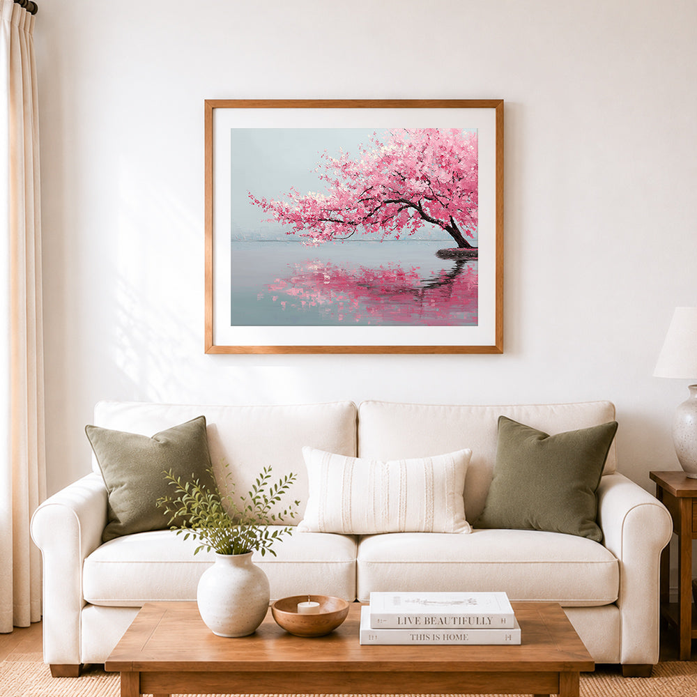 Finished pink cherry blossom tree reflecting on calm water cross stitch artwork displayed as home decor