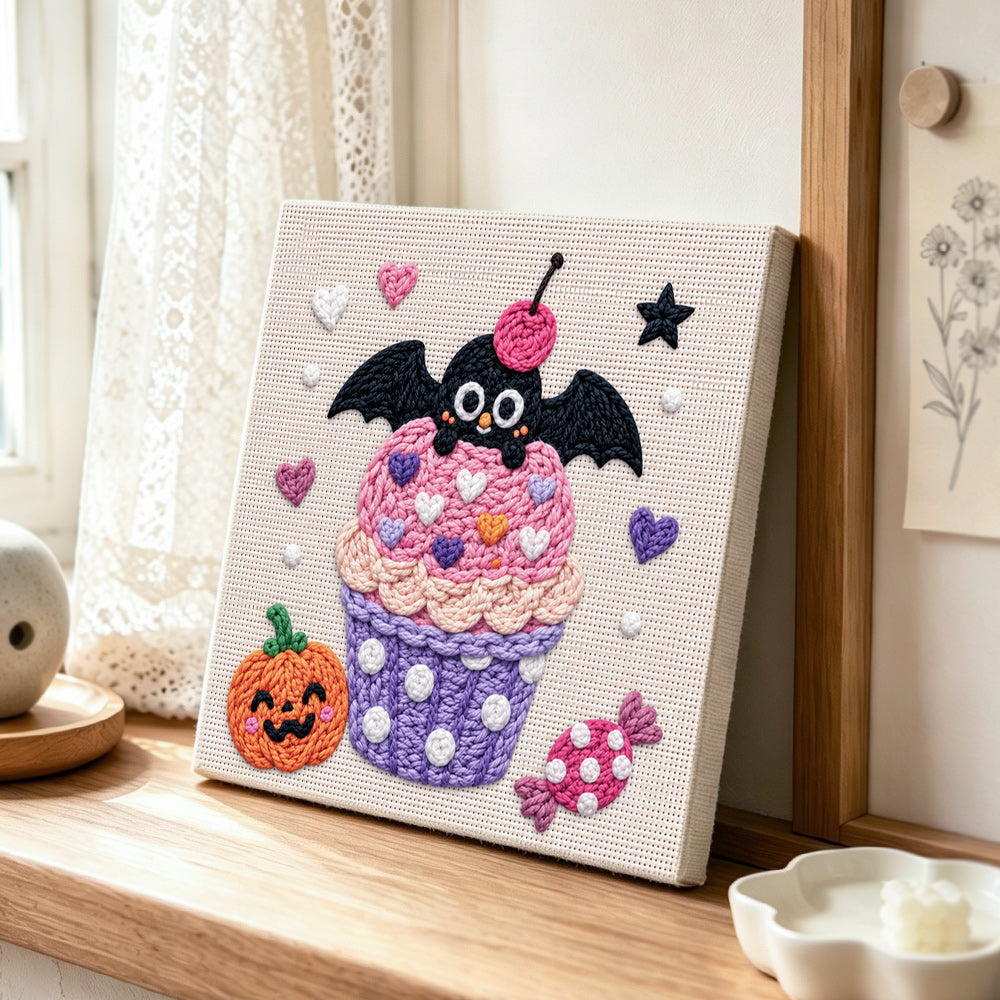 Pink cupcake with bat punch needle artwork displayed on a table