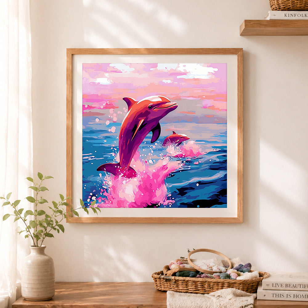 Finished pink dolphin ocean cross stitch artwork displayed as home decor