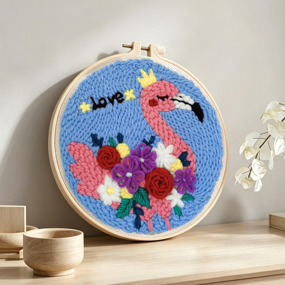 Pink flamingo with colorful flowers punch needle artwork displayed on a table