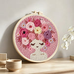 Pink floral crown girl punch needle artwork displayed on a table