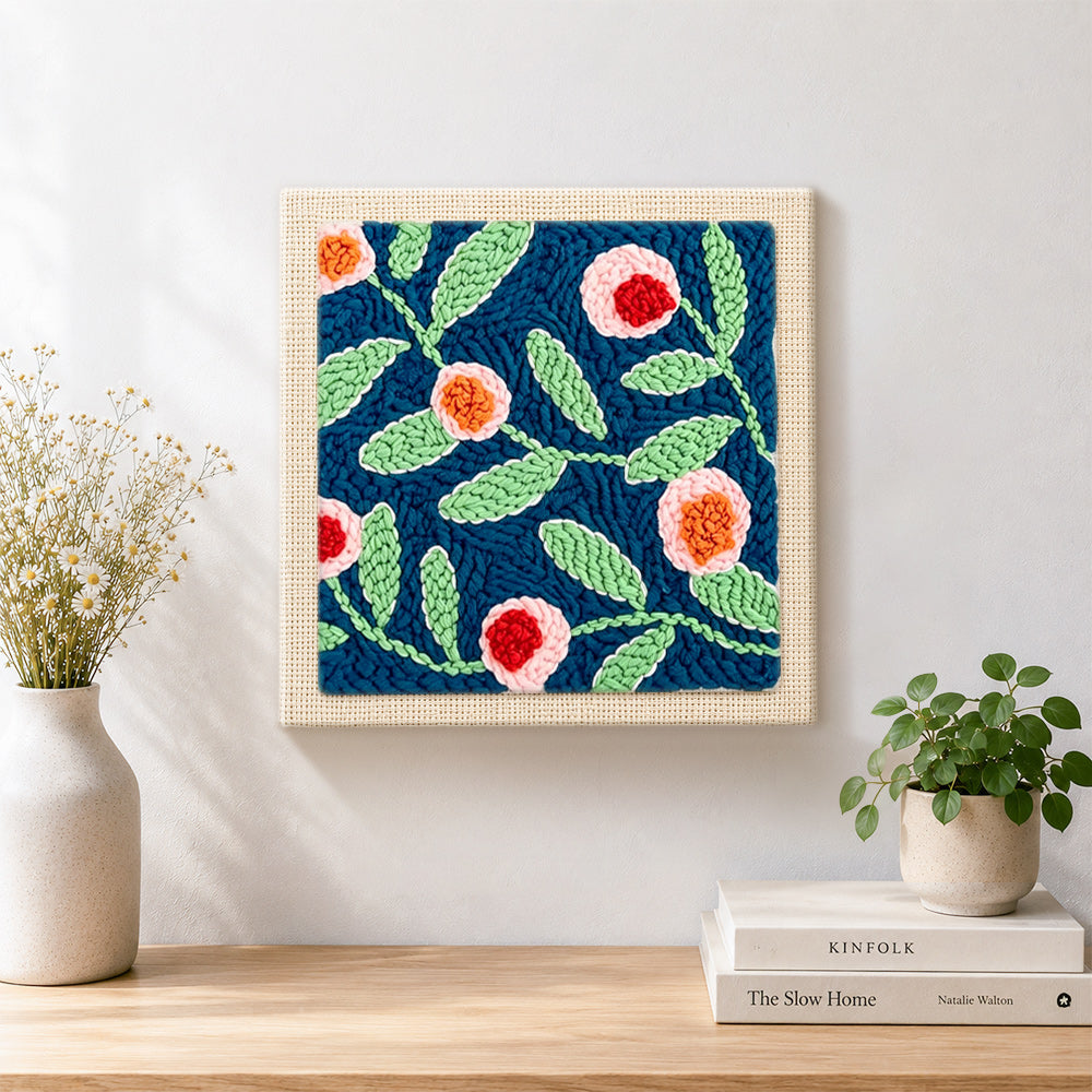 Finished pink flowers with green leaves artwork displayed on a wall