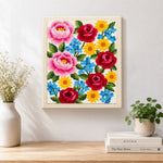 Finished pink peonies, red roses and blue forget-me-nots artwork displayed on a wall