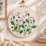 Pink thistle and daisies embroidery hoop wall art displayed as warm and cozy handmade home decor