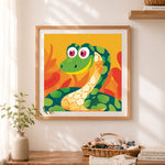 Finished playful cartoon snake cross stitch artwork displayed as home decor